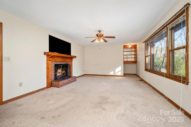 unfurnished living room with carpet, ceiling fan, and a brick fireplace