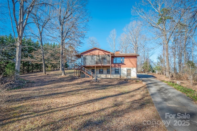 view of front of house featuring a front yard and a sunroom