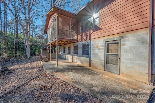 rear view of house featuring a patio area and a sunroom