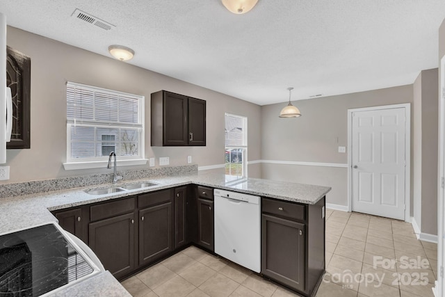 kitchen featuring a sink, white dishwasher, pendant lighting, a peninsula, and visible vents