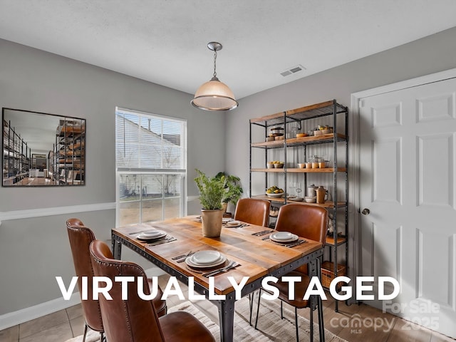 dining space with light tile patterned floors, baseboards, and visible vents