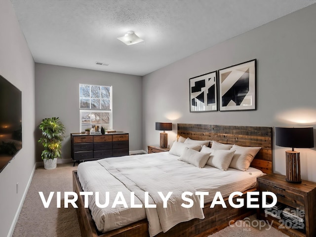 carpeted bedroom with baseboards, a textured ceiling, and visible vents