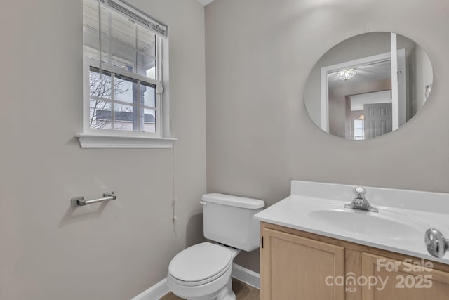 bathroom with toilet, baseboards, and vanity