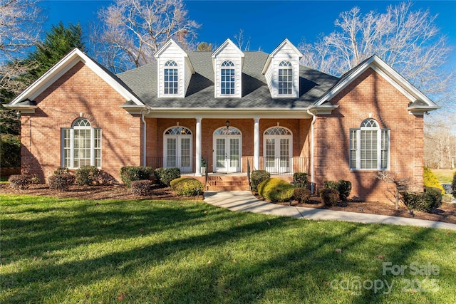 view of front facade with covered porch, french doors, and a front yard