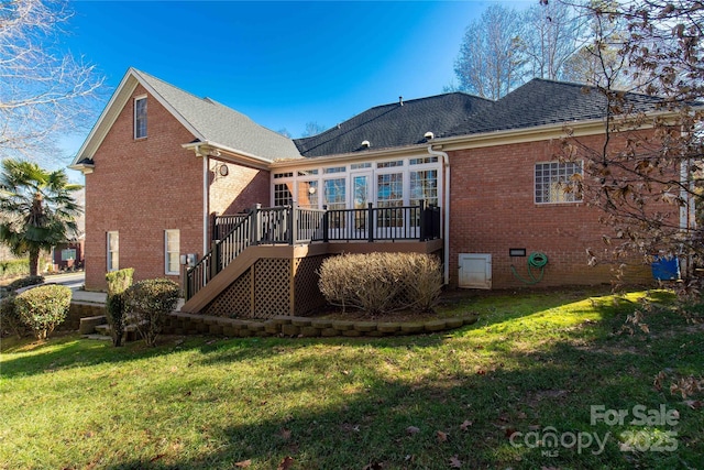 back of house featuring a wooden deck and a yard