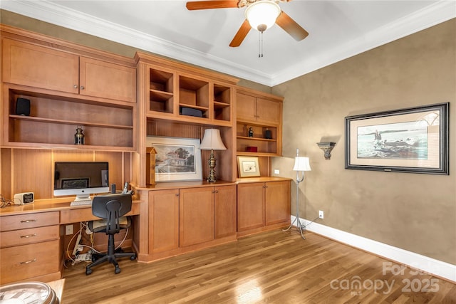 office space with built in desk, light wood-type flooring, ceiling fan, and crown molding