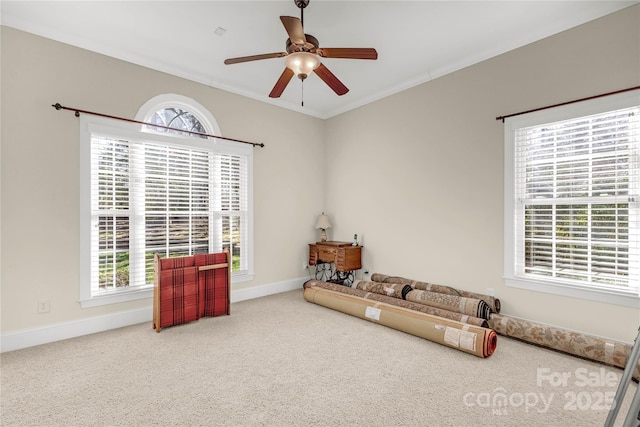 sitting room with carpet, ornamental molding, ceiling fan, and a healthy amount of sunlight