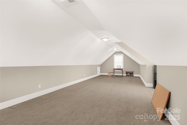 bonus room with light colored carpet and lofted ceiling