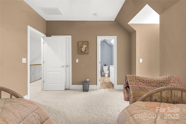 carpeted bedroom featuring lofted ceiling and connected bathroom