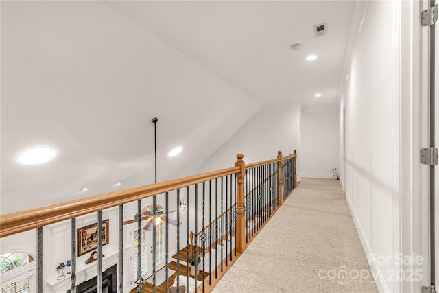 hallway featuring light colored carpet, crown molding, and vaulted ceiling