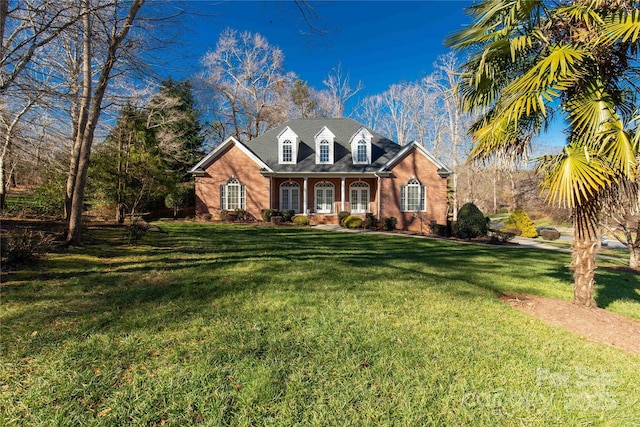 new england style home featuring covered porch and a front lawn