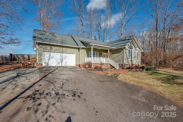 single story home with a front lawn, covered porch, and a garage