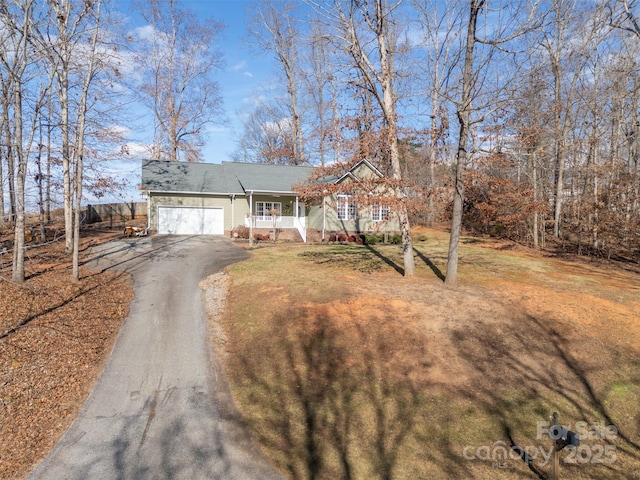 view of front of home with a porch, a garage, and a front lawn