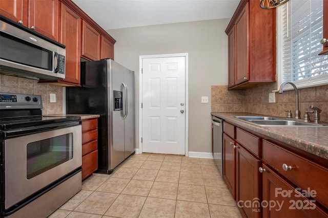 kitchen featuring backsplash, sink, light tile patterned flooring, and appliances with stainless steel finishes