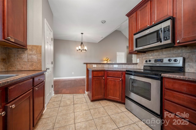 kitchen featuring a chandelier, light tile patterned floors, stainless steel appliances, and pendant lighting