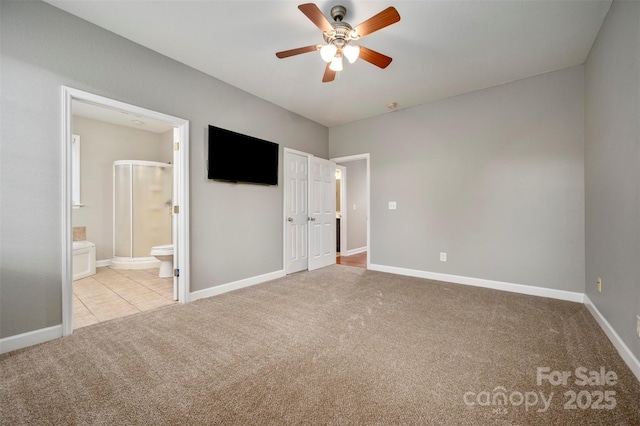 unfurnished bedroom featuring ceiling fan, light colored carpet, and ensuite bath