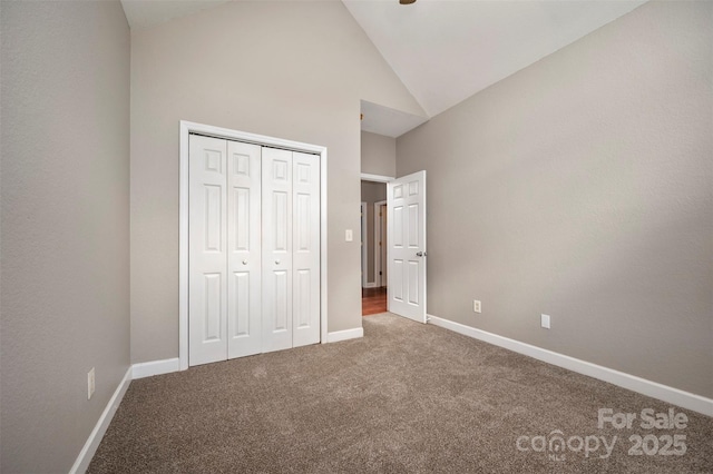 unfurnished bedroom with carpet floors, high vaulted ceiling, and a closet