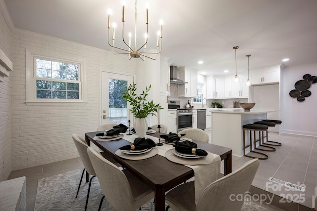 tiled dining space featuring a notable chandelier, sink, and brick wall