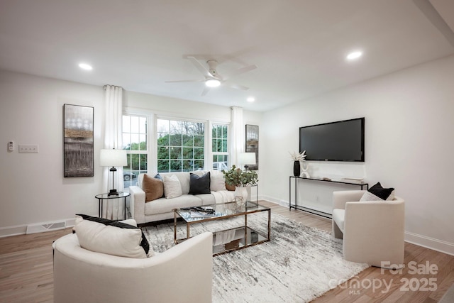 living room with hardwood / wood-style flooring and ceiling fan