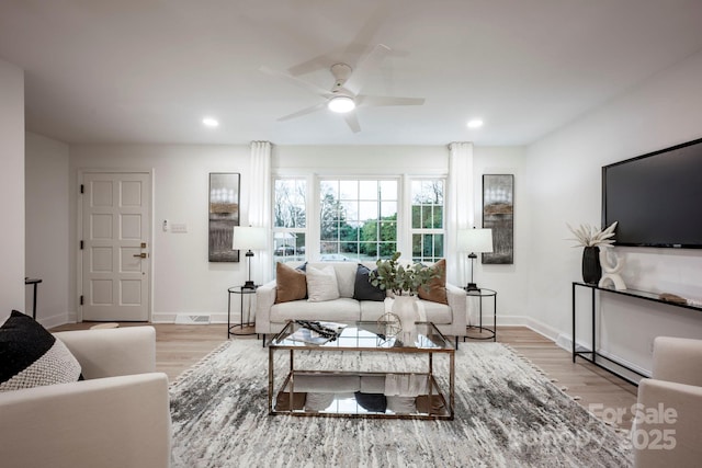 living room featuring ceiling fan and light hardwood / wood-style flooring