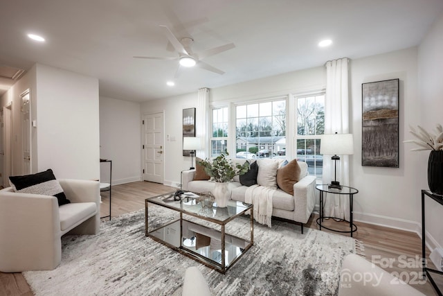 living room featuring light hardwood / wood-style floors and ceiling fan