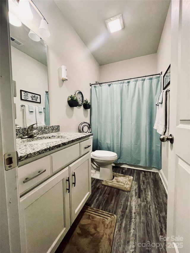 full bathroom with shower / bath combination with curtain, vanity, hardwood / wood-style flooring, and toilet