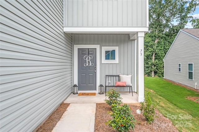 view of exterior entry featuring a yard