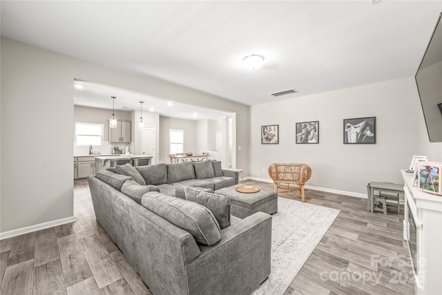 living room with light hardwood / wood-style flooring and sink