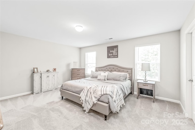 bedroom featuring light carpet and multiple windows