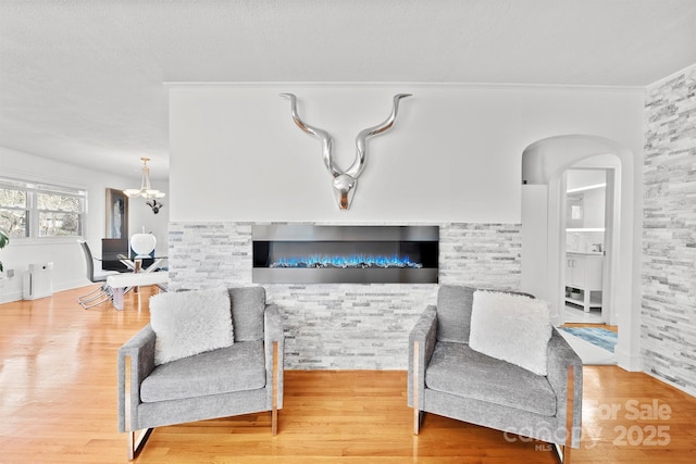 living room featuring crown molding, hardwood / wood-style floors, and a notable chandelier