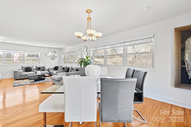 dining space featuring hardwood / wood-style floors and an inviting chandelier