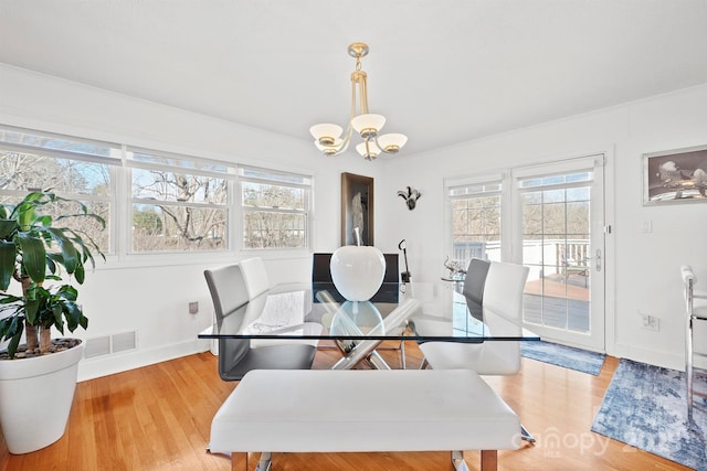 dining room featuring an inviting chandelier and light hardwood / wood-style flooring