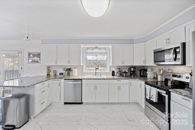 kitchen featuring kitchen peninsula, appliances with stainless steel finishes, decorative backsplash, sink, and white cabinets