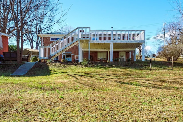 rear view of property with brick siding, stairway, a yard, and a deck