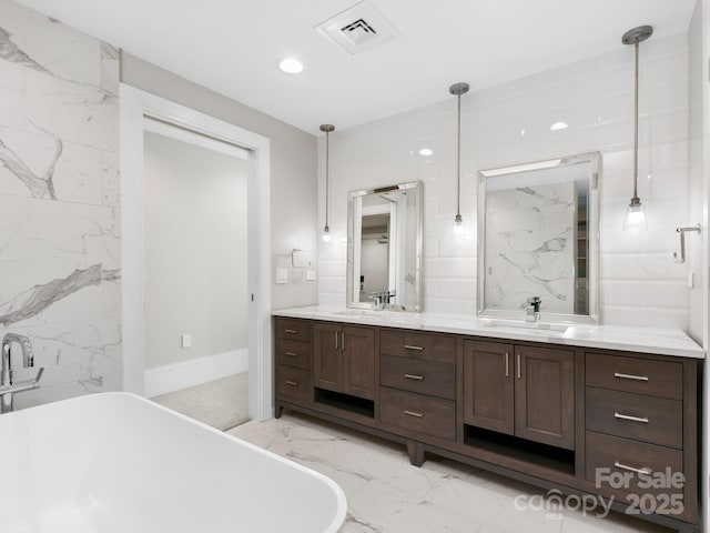 bathroom featuring a bathtub, vanity, and tile walls