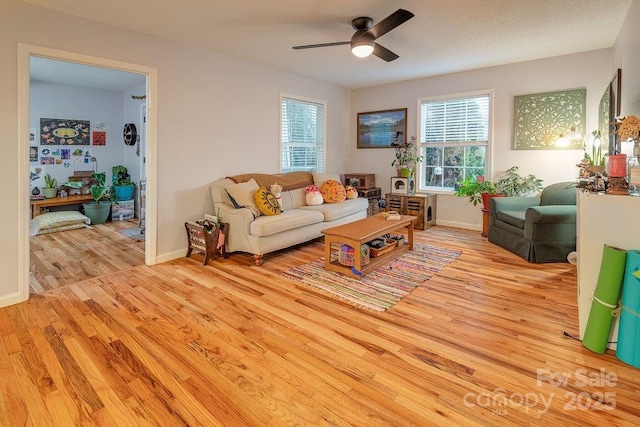 living room with ceiling fan, light wood-type flooring, and a wealth of natural light