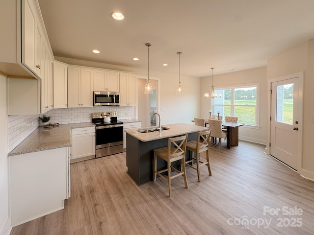 46 Griffin Rd Unit 2, Pageland, SC 29728 - kitchen with stainless steel appliances, a sink, white cabinetry, tasteful backsplash, and light wood finished floors