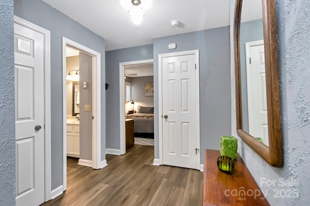 hall featuring dark wood-type flooring and a textured ceiling