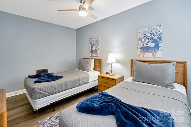 bedroom with ceiling fan and dark wood-type flooring