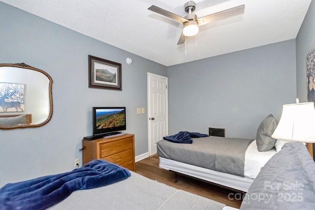 bedroom featuring ceiling fan and dark wood-type flooring