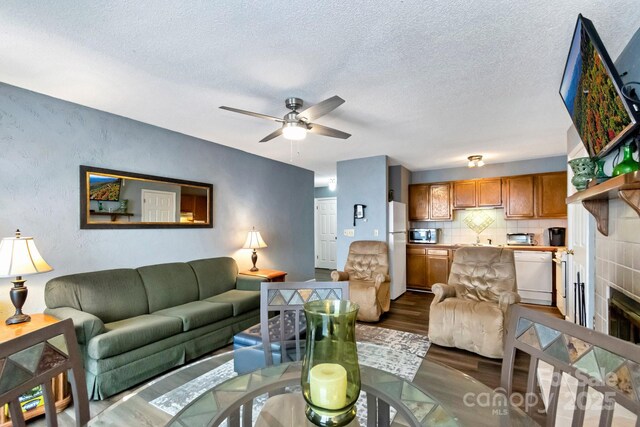 301 Pinnacle Inn Rd Unit 4313, Beech Mountain, NC 28604 - living room with dark wood-style floors, a ceiling fan, a textured ceiling, a textured wall, and a tiled fireplace