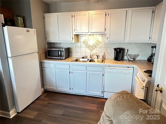 kitchen featuring decorative backsplash, white appliances, dark wood-type flooring, sink, and white cabinets