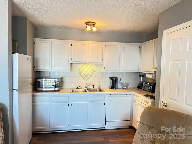 kitchen with a textured ceiling, white cabinetry, sink, and white appliances