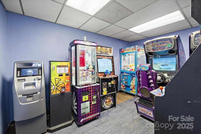 rec room featuring a paneled ceiling and carpet