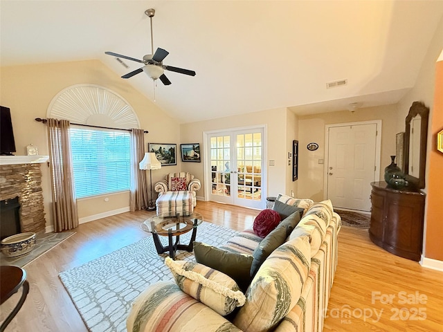 living room with vaulted ceiling, a fireplace, light wood-type flooring, and ceiling fan