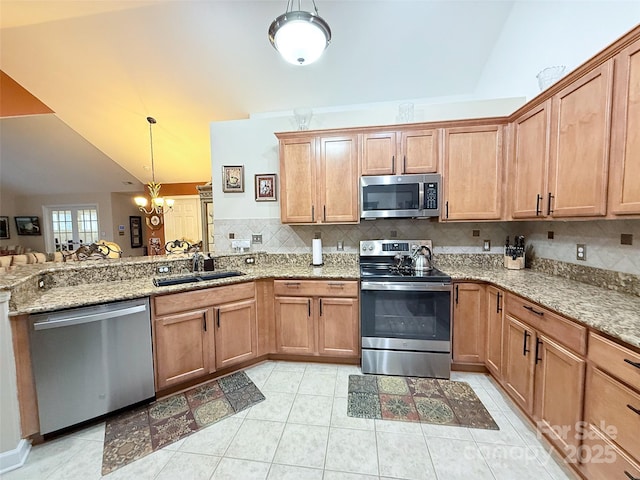 kitchen with sink, vaulted ceiling, hanging light fixtures, a notable chandelier, and appliances with stainless steel finishes