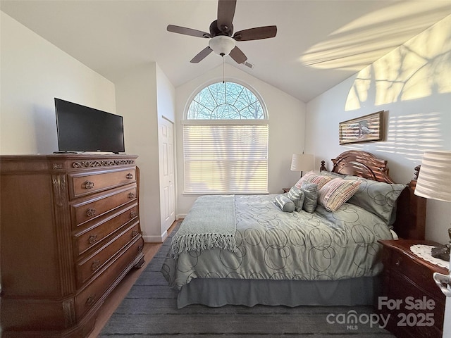 bedroom with ceiling fan, lofted ceiling, and wood-type flooring