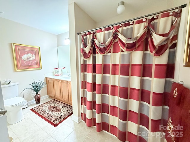 bathroom with toilet, vanity, tile patterned floors, and curtained shower