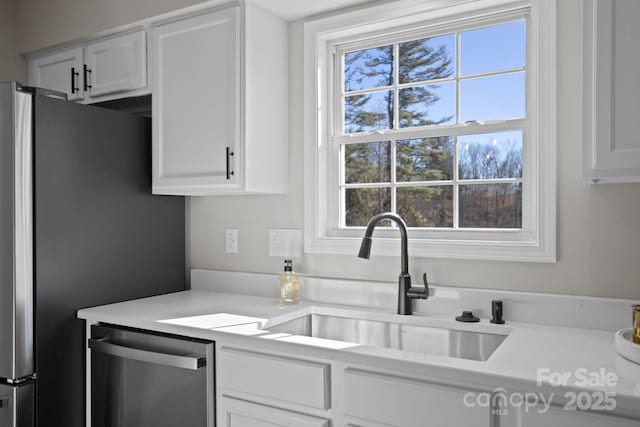 kitchen with sink, white cabinets, and appliances with stainless steel finishes