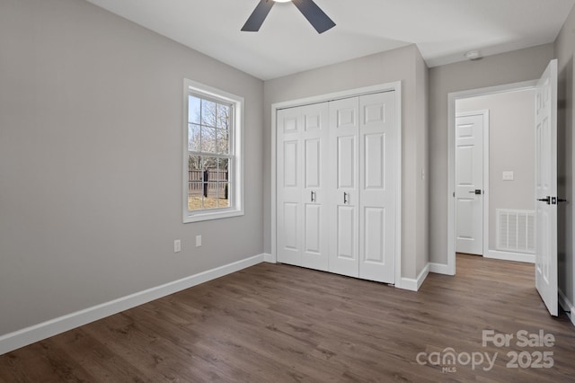 unfurnished bedroom featuring a closet, ceiling fan, and dark wood-type flooring